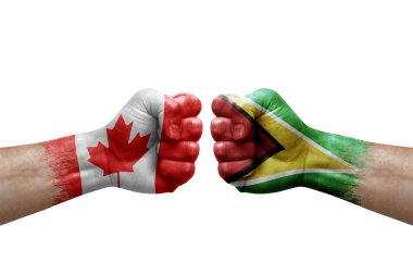 Two hands punch to each others on white background. Country flags painted fists, conflict crisis concept between canada and guyana