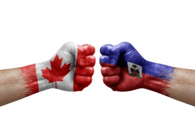 Two hands punch to each others on white background. Country flags painted fists, conflict crisis concept between canada and haiti