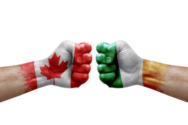Two hands punch to each others on white background. Country flags painted fists, conflict crisis concept between canada and ireland