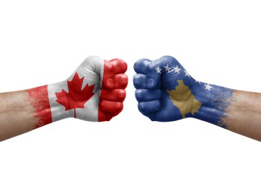 Two hands punch to each others on white background. Country flags painted fists, conflict crisis concept between canada and kosovo