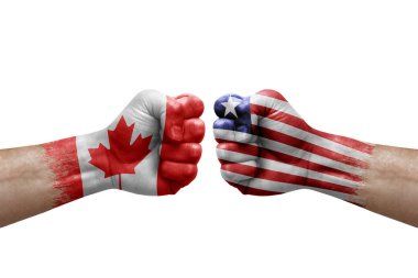 Two hands punch to each others on white background. Country flags painted fists, conflict crisis concept between canada and liberia
