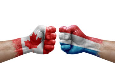 Two hands punch to each others on white background. Country flags painted fists, conflict crisis concept between canada and luxembourg