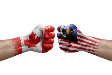 Two hands punch to each others on white background. Country flags painted fists, conflict crisis concept between canada and malaysia