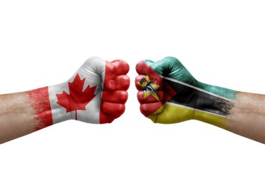 Two hands punch to each others on white background. Country flags painted fists, conflict crisis concept between canada and mozambique