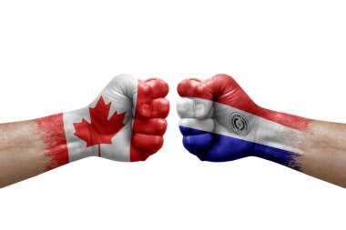 Two hands punch to each others on white background. Country flags painted fists, conflict crisis concept between canada and paraguay