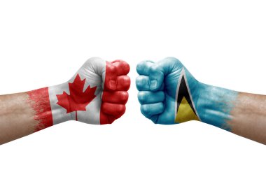 Two hands punch to each others on white background. Country flags painted fists, conflict crisis concept between canada and saint lucia