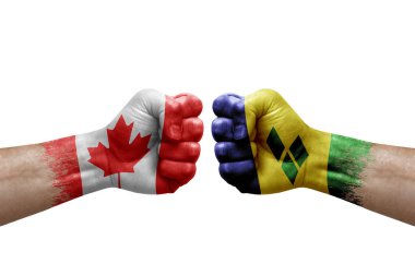 Two hands punch to each others on white background. Country flags painted fists, conflict crisis concept between canada and saint vincent and the grenadines