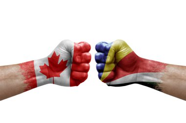 Two hands punch to each others on white background. Country flags painted fists, conflict crisis concept between canada and seychelles