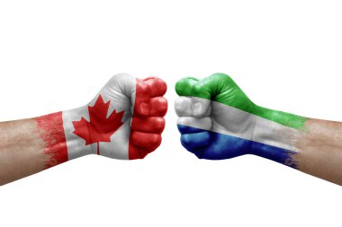 Two hands punch to each others on white background. Country flags painted fists, conflict crisis concept between canada and sierra leone