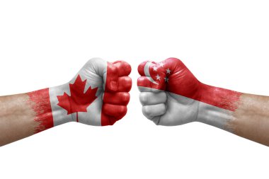 Two hands punch to each others on white background. Country flags painted fists, conflict crisis concept between canada and singapore