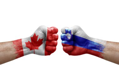 Two hands punch to each others on white background. Country flags painted fists, conflict crisis concept between canada and slovenia