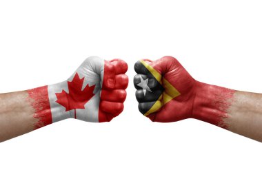Two hands punch to each others on white background. Country flags painted fists, conflict crisis concept between canada and timor leste