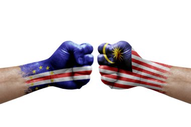 Two hands punch to each others on white background. Country flags painted fists, conflict crisis concept between cape verde and malaysia