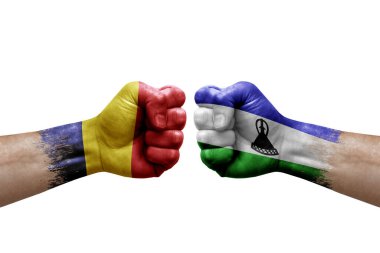 Two hands punch to each others on white background. Country flags painted fists, conflict crisis concept between chad and lesotho