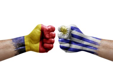 Two hands punch to each others on white background. Country flags painted fists, conflict crisis concept between chad and uruguay