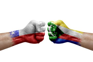 Two hands punch to each others on white background. Country flags painted fists, conflict crisis concept between chile and comoros