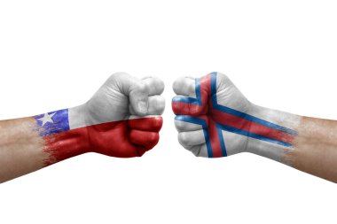 Two hands punch to each others on white background. Country flags painted fists, conflict crisis concept between chile and faroe islands