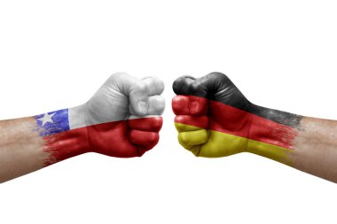 Two hands punch to each others on white background. Country flags painted fists, conflict crisis concept between chile and germany