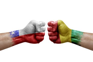 Two hands punch to each others on white background. Country flags painted fists, conflict crisis concept between chile and guinea