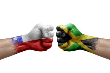 Two hands punch to each others on white background. Country flags painted fists, conflict crisis concept between chile and jamaica