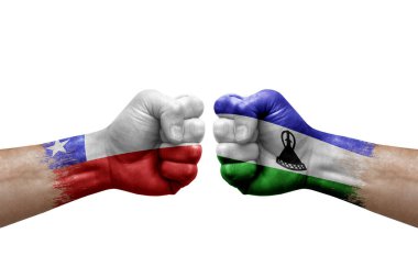 Two hands punch to each others on white background. Country flags painted fists, conflict crisis concept between chile and lesotho