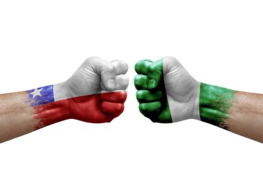 Two hands punch to each others on white background. Country flags painted fists, conflict crisis concept between chile and nigeria