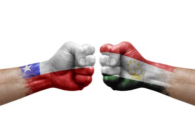 Two hands punch to each others on white background. Country flags painted fists, conflict crisis concept between chile and tajikistan