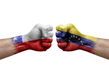 Two hands punch to each others on white background. Country flags painted fists, conflict crisis concept between chile and venezuela