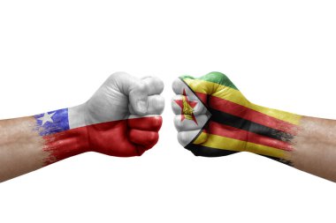 Two hands punch to each others on white background. Country flags painted fists, conflict crisis concept between chile and zimbabwe