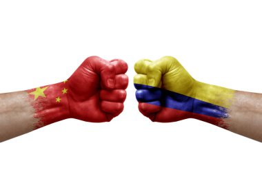 Two hands punch to each others on white background. Country flags painted fists, conflict crisis concept between china and colombia