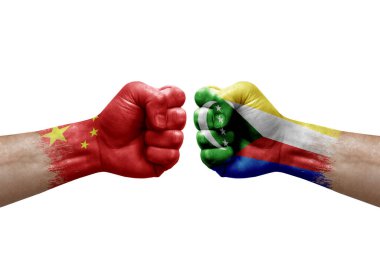 Two hands punch to each others on white background. Country flags painted fists, conflict crisis concept between china and comoros