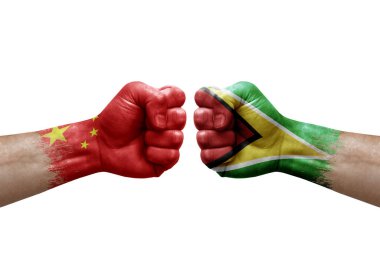 Two hands punch to each others on white background. Country flags painted fists, conflict crisis concept between china and guyana