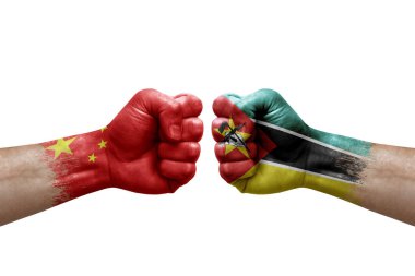 Two hands punch to each others on white background. Country flags painted fists, conflict crisis concept between china and mozambique