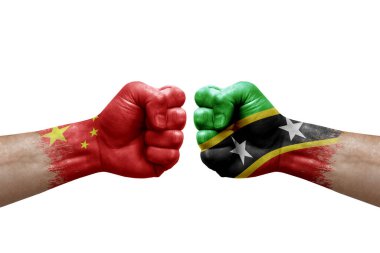 Two hands punch to each others on white background. Country flags painted fists, conflict crisis concept between china and saint kitts and nevis