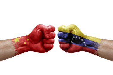 Two hands punch to each others on white background. Country flags painted fists, conflict crisis concept between china and venezuela