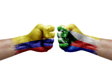 Two hands punch to each others on white background. Country flags painted fists, conflict crisis concept between colombia and comoros