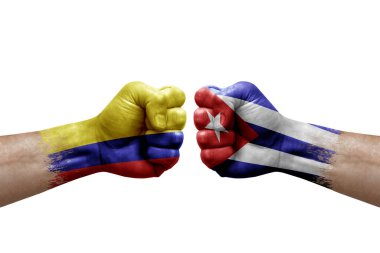 Two hands punch to each others on white background. Country flags painted fists, conflict crisis concept between colombia and cuba