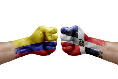 Two hands punch to each others on white background. Country flags painted fists, conflict crisis concept between colombia and dominican republic