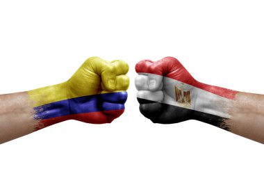 Two hands punch to each others on white background. Country flags painted fists, conflict crisis concept between colombia and egypt