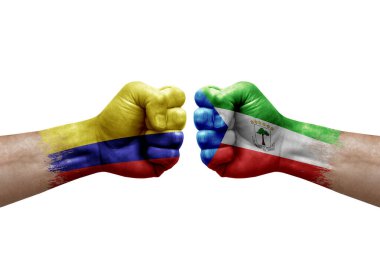 Two hands punch to each others on white background. Country flags painted fists, conflict crisis concept between colombia and equatorial guinea