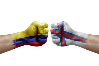 Two hands punch to each others on white background. Country flags painted fists, conflict crisis concept between colombia and faroe islands