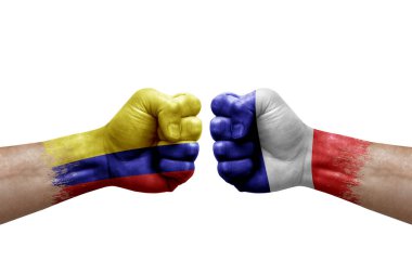 Two hands punch to each others on white background. Country flags painted fists, conflict crisis concept between colombia and france