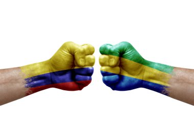 Two hands punch to each others on white background. Country flags painted fists, conflict crisis concept between colombia and gabon