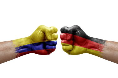 Two hands punch to each others on white background. Country flags painted fists, conflict crisis concept between colombia and germany