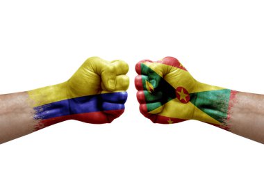 Two hands punch to each others on white background. Country flags painted fists, conflict crisis concept between colombia and grenada