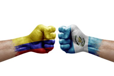 Two hands punch to each others on white background. Country flags painted fists, conflict crisis concept between colombia and guatemala