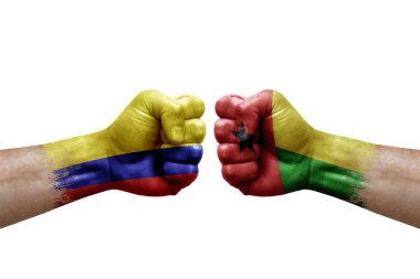 Two hands punch to each others on white background. Country flags painted fists, conflict crisis concept between colombia and guinea-bissau
