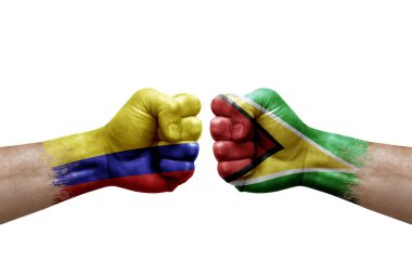 Two hands punch to each others on white background. Country flags painted fists, conflict crisis concept between colombia and guyana