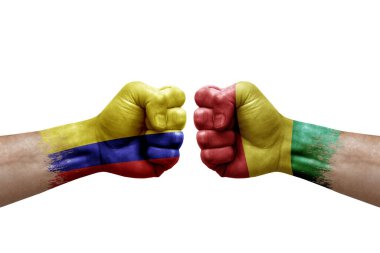 Two hands punch to each others on white background. Country flags painted fists, conflict crisis concept between colombia and guinea