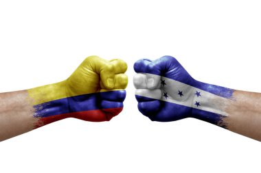 Two hands punch to each others on white background. Country flags painted fists, conflict crisis concept between colombia and honduras
